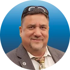 Profile Picture of Douglas V Gibbs wearing a suit and tie , smiling. The background is a gradient blue color.